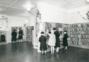 black and white photo of children browsing book shelves