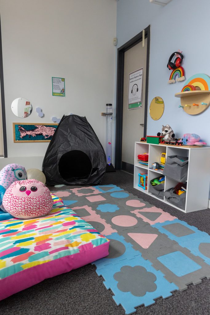 room with items on wall, black tent, bean bag and large soft toys