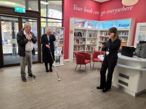 Three people standing with canes, two wearing glasses