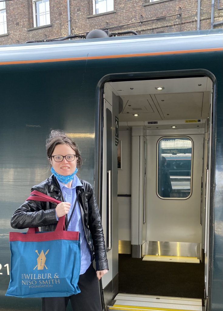 A young woman with large bag about to board a train