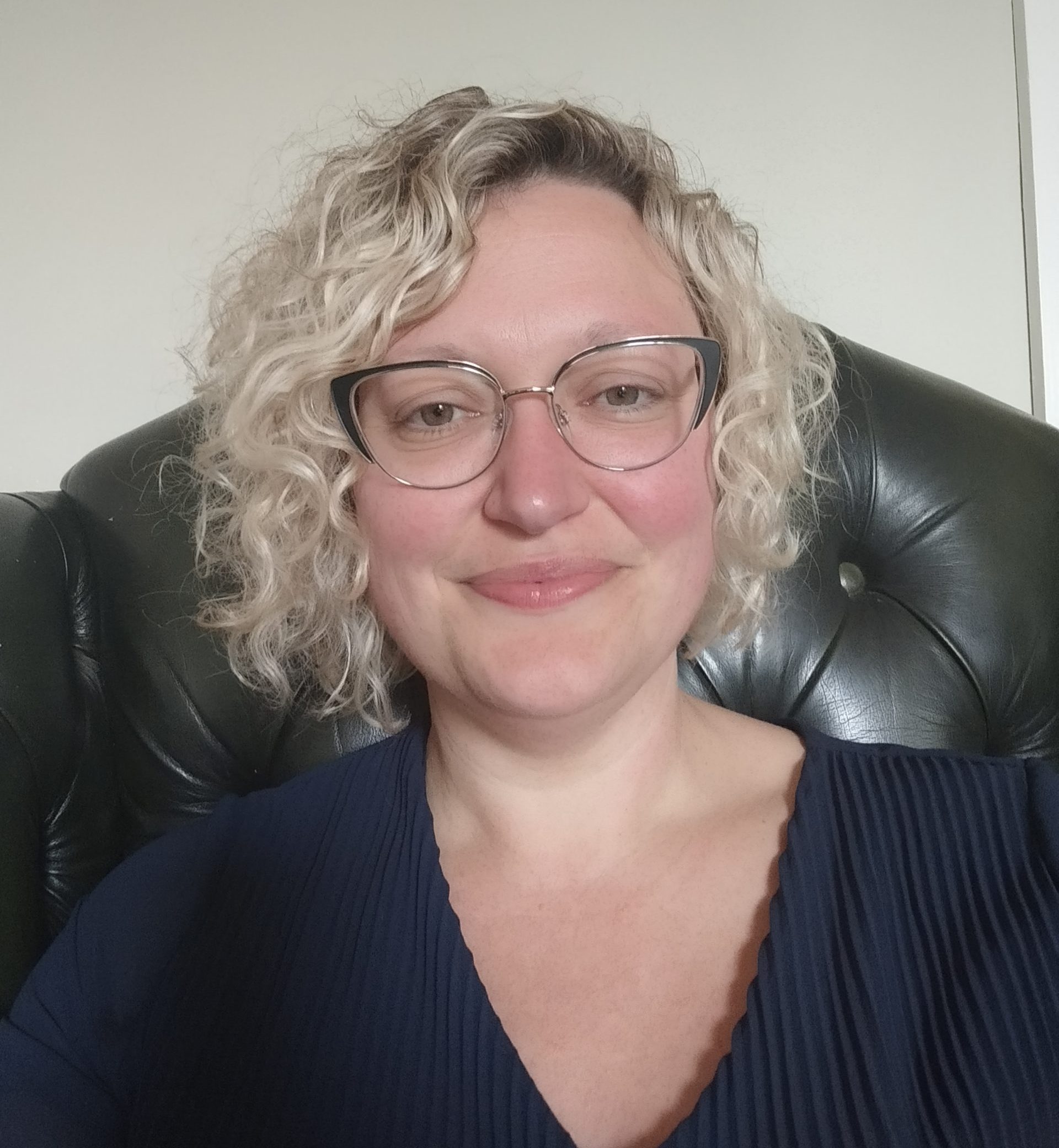 woman with short blonde hair and glasses