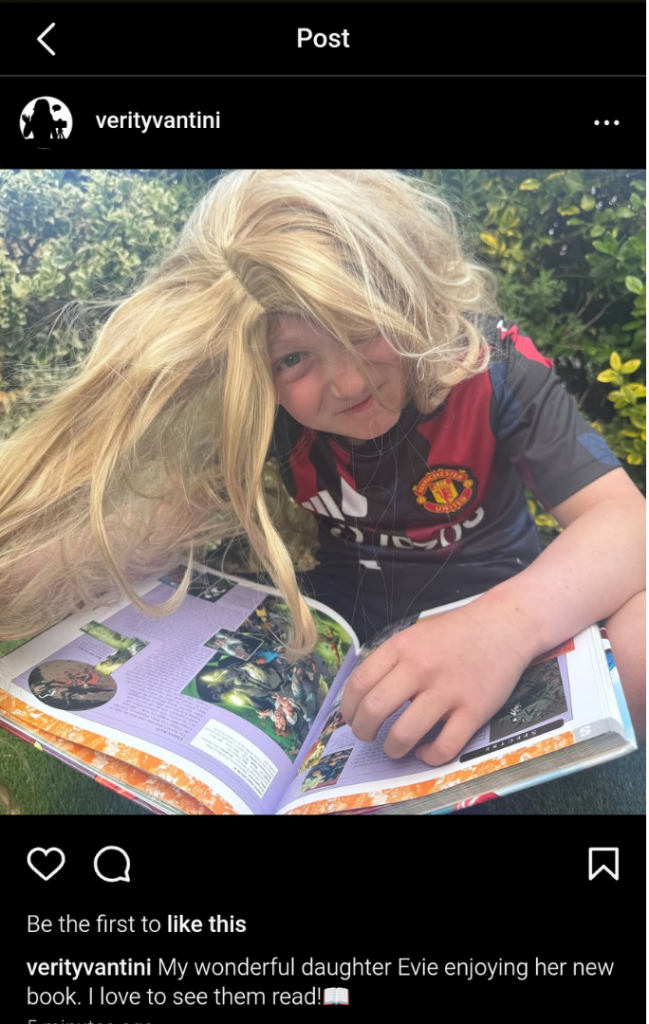 screenshot of instagram post: boy in long blonde wig, in a football top reading a book