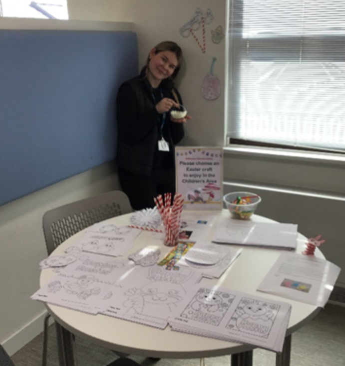 woman stood behind table of activity sheets