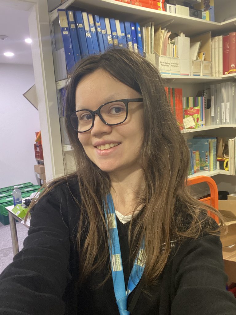 woman with long dark hair and glasses smiling at camera