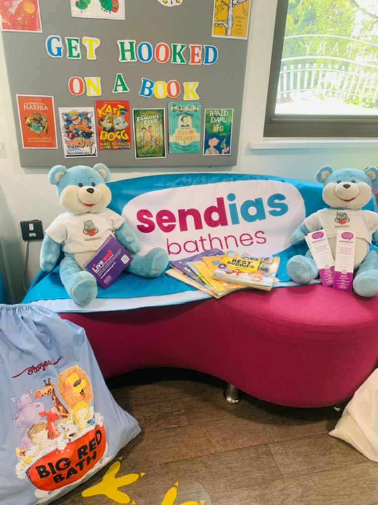 Sendias signage on a sofa with blue teddy bears, books and a story sack