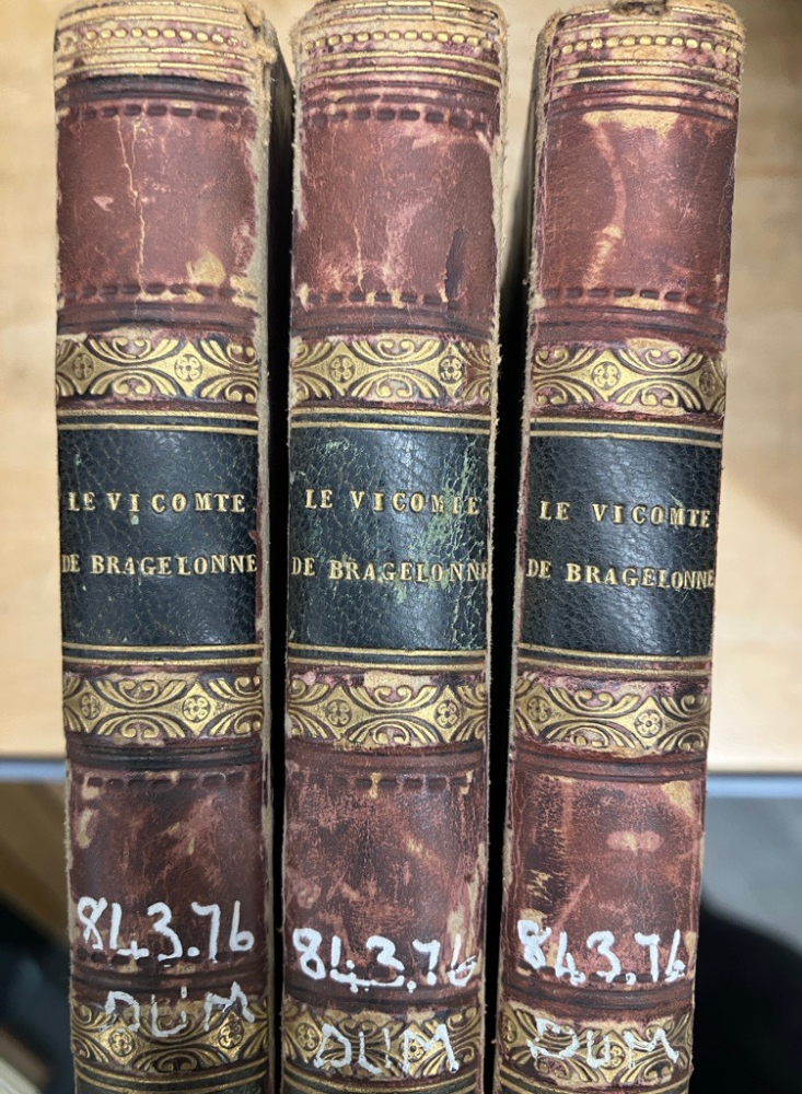 Spines of 3 copies of Le Vicomte De Bragelonne. worn red, gold and black with embossed line decoration.