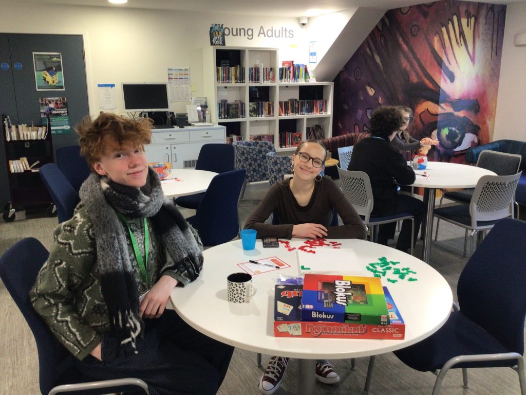 teenagers sat at a table with board game