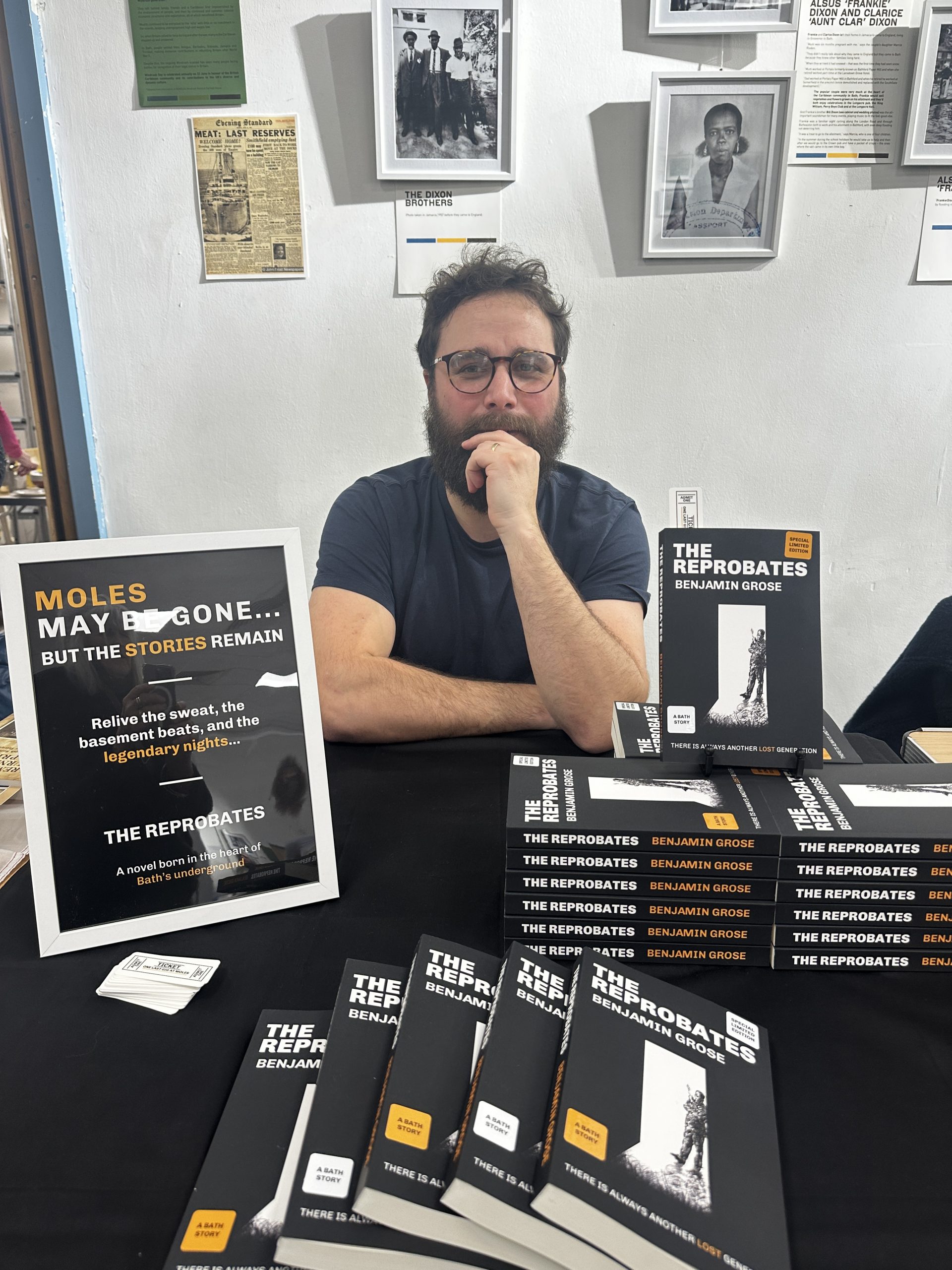 Man sat thinking behind book display