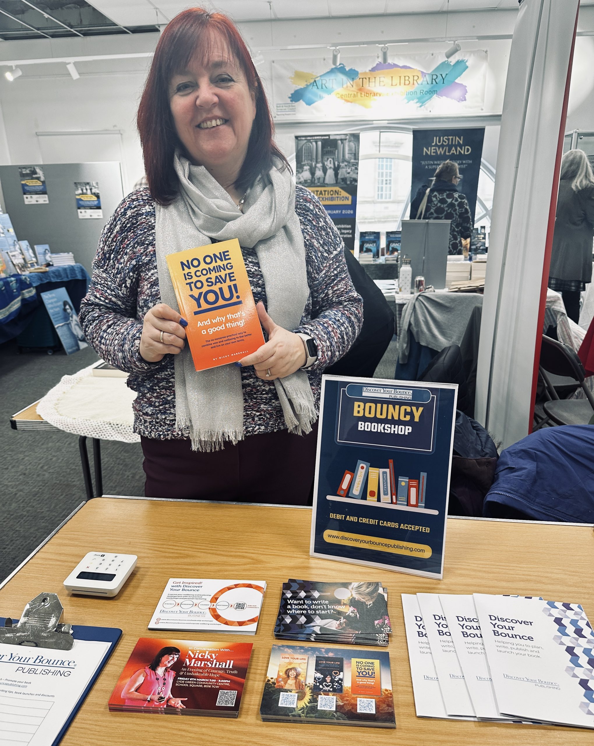 woman smiling holding a book 'no one is coming to save you'