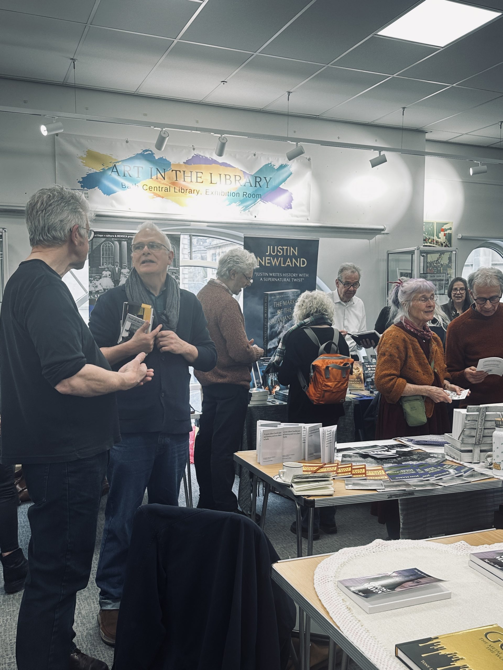crowd of adults around tables of books