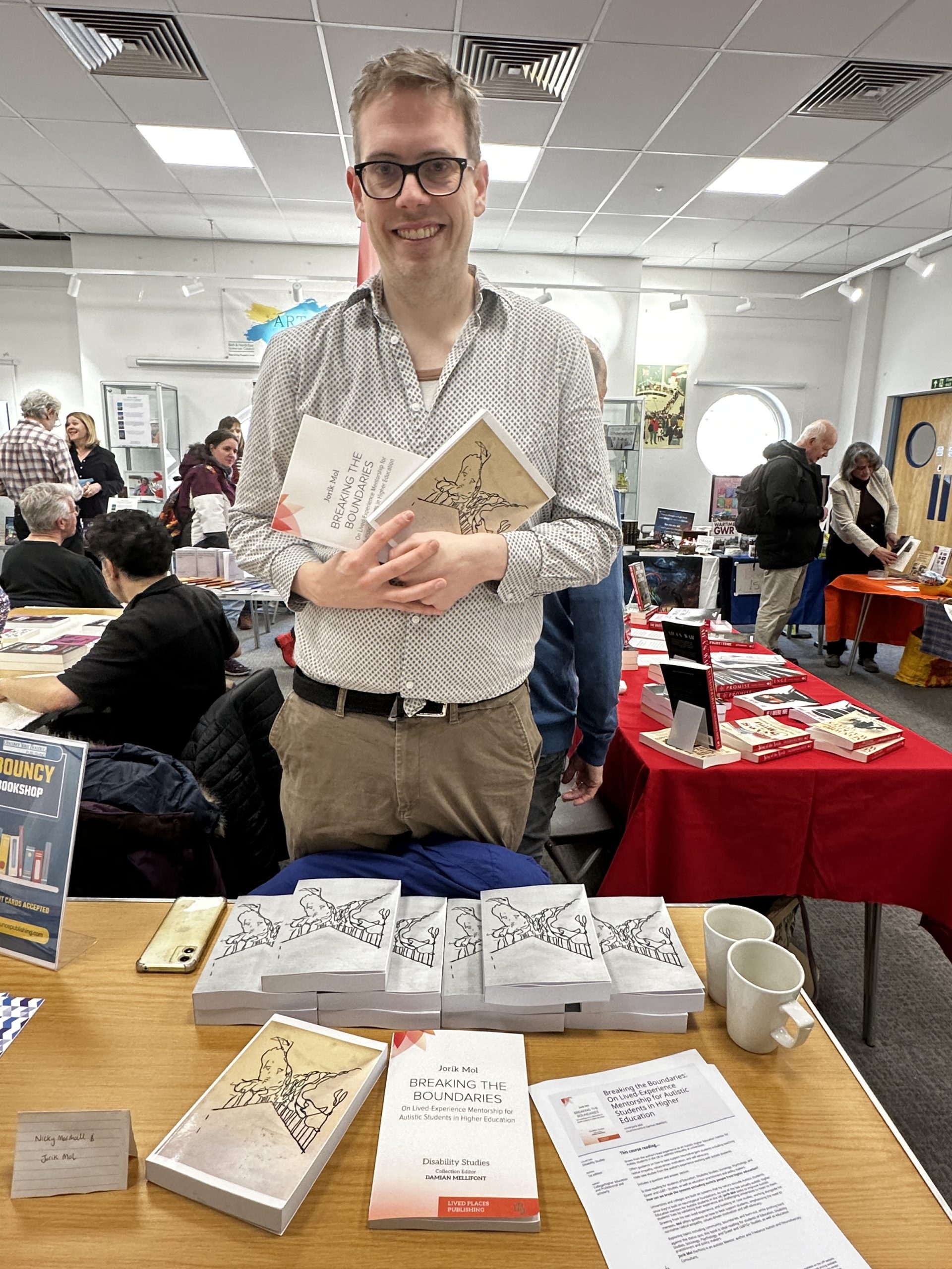 Man smiling holding books