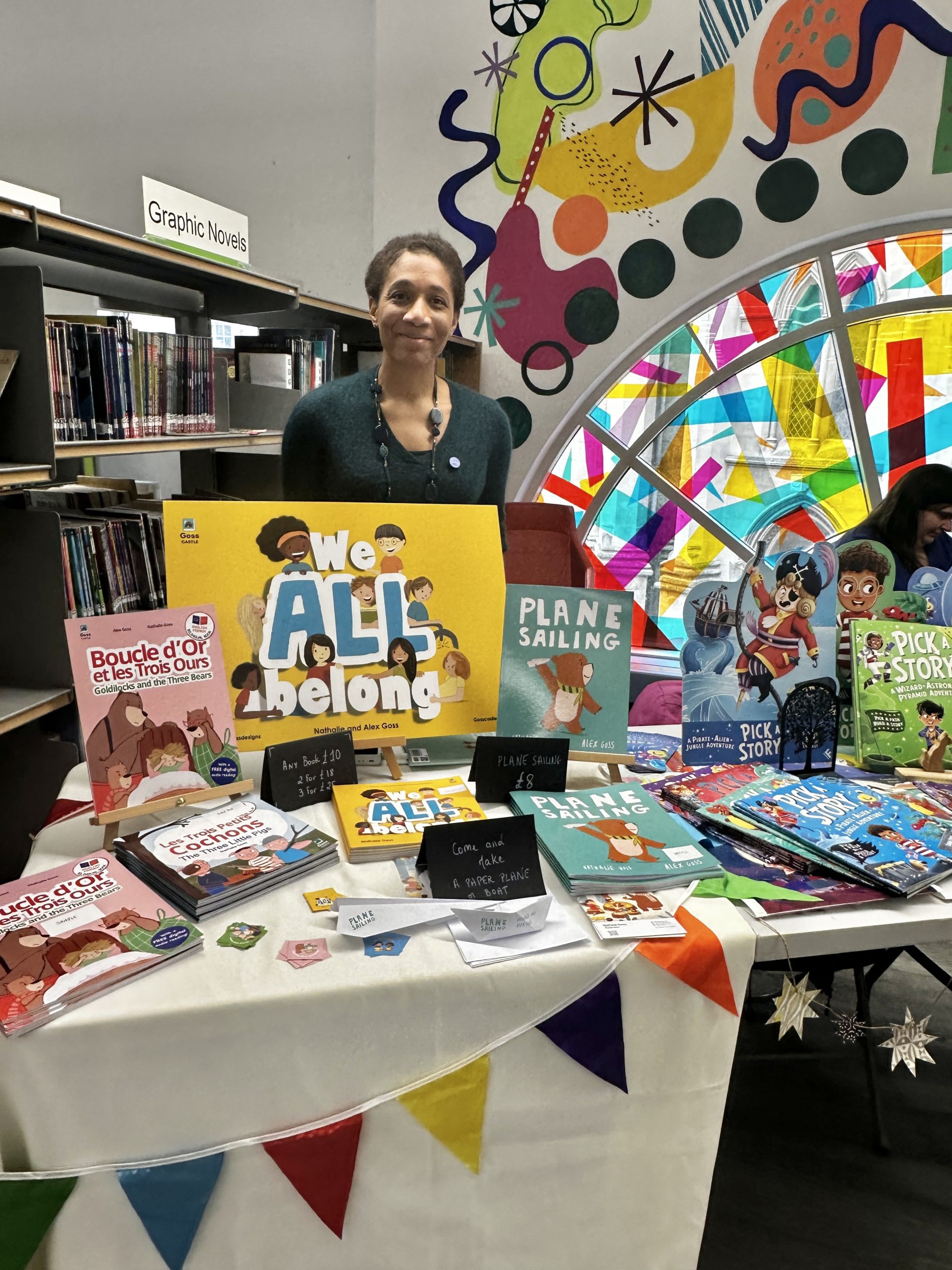 woman stood by books displayed on table with bunting