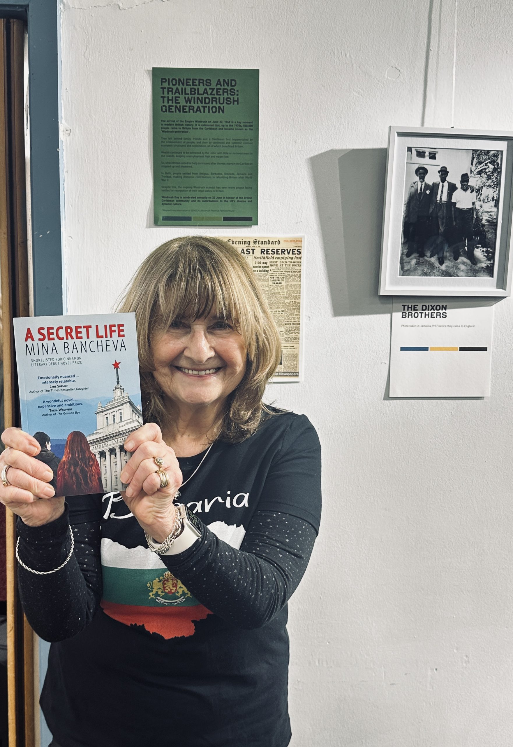 Female author smiling and holding up 'A Secret life' by Mina Bancheva