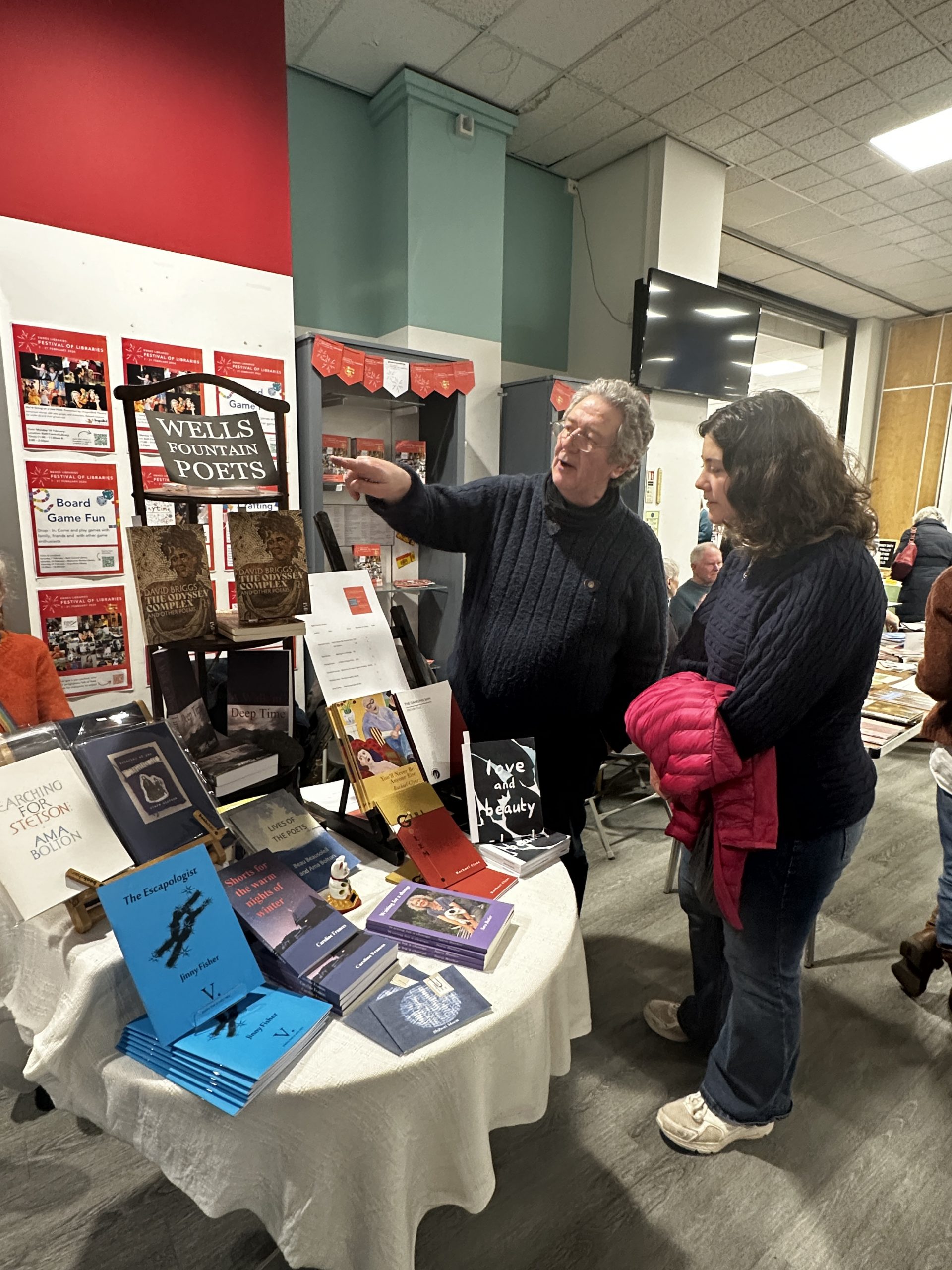 two people stood looking at display, one pointing to a poster