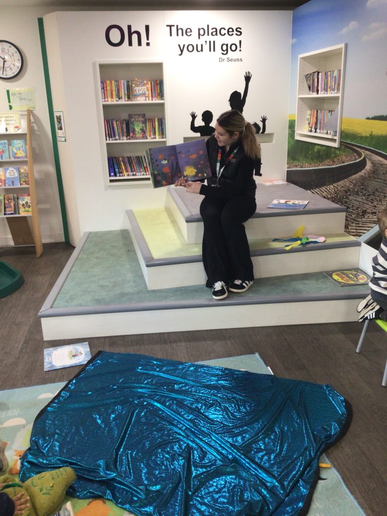 Person reading a book on step in library