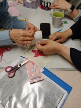 two people's hands sewing