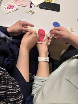 two people's hands sewing
